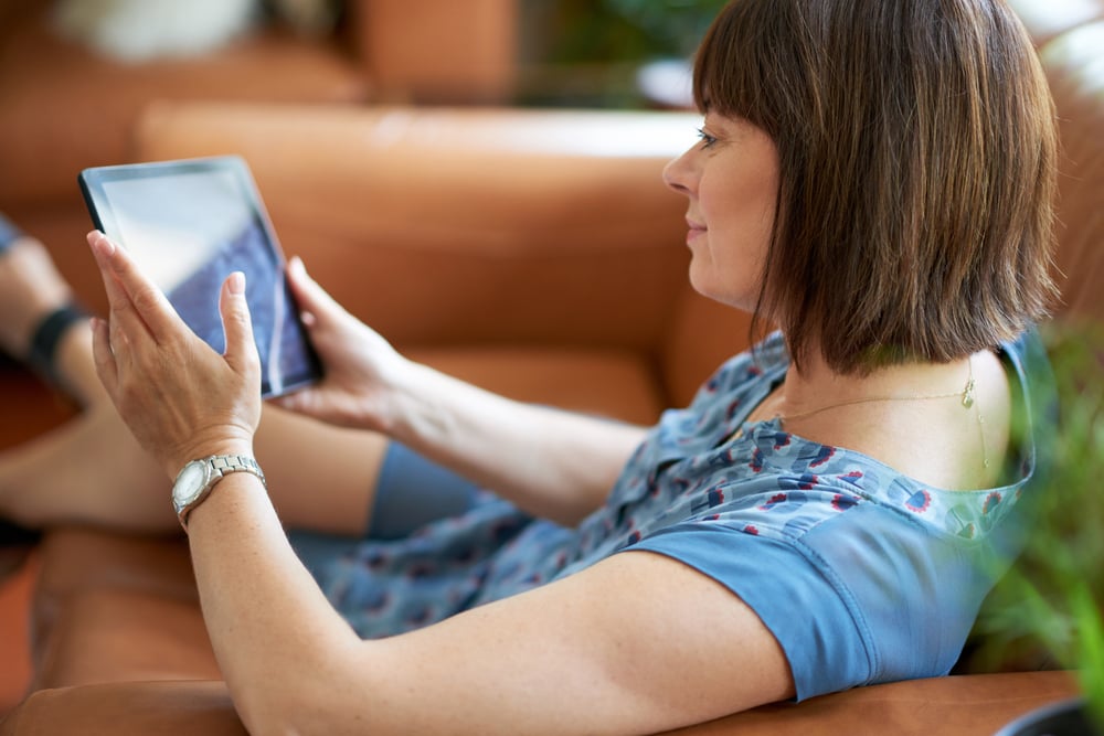 Mature woman browsing the internet on a digital tablet